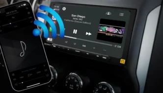 A cellphone with bluetooth bars coming out of it going towards a car audio radio screen