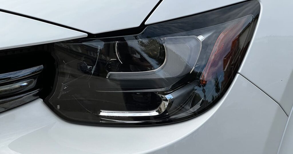 Closeup of a headlight on a white car