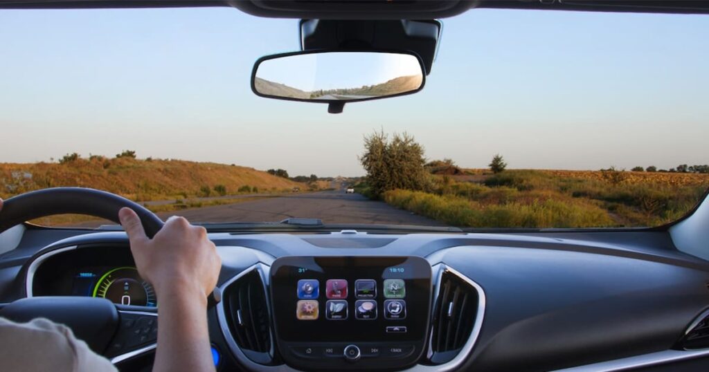 A view of a road through the front of the car